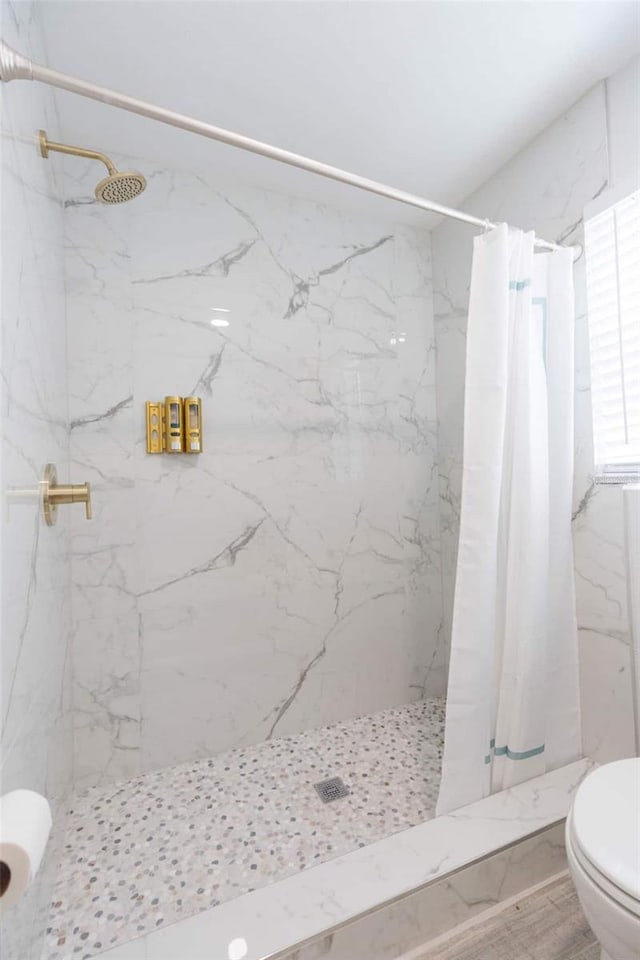 bathroom featuring a shower with curtain and toilet