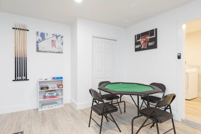 playroom featuring washer / clothes dryer and light hardwood / wood-style flooring