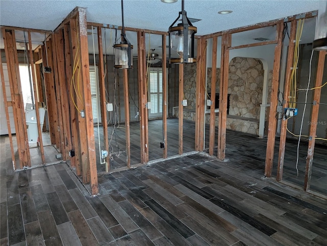 misc room with dark wood-type flooring and a textured ceiling