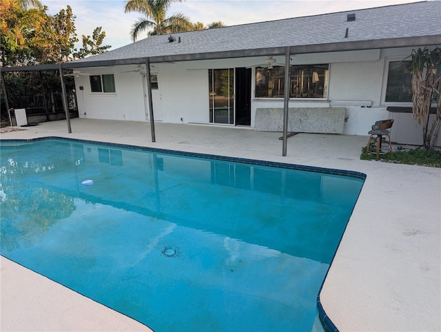 view of swimming pool with ceiling fan and a patio