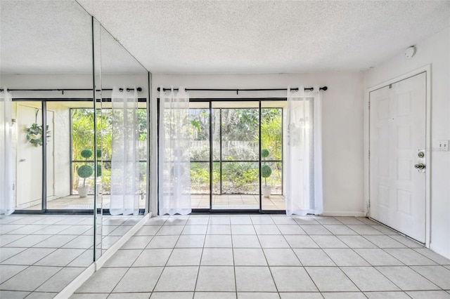 interior space featuring light tile patterned floors and a textured ceiling