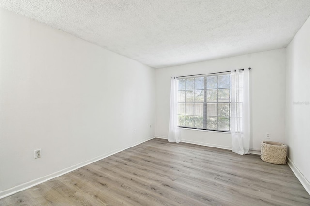 empty room featuring light hardwood / wood-style flooring and a textured ceiling