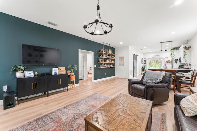 living room with indoor bar, a notable chandelier, and light hardwood / wood-style flooring