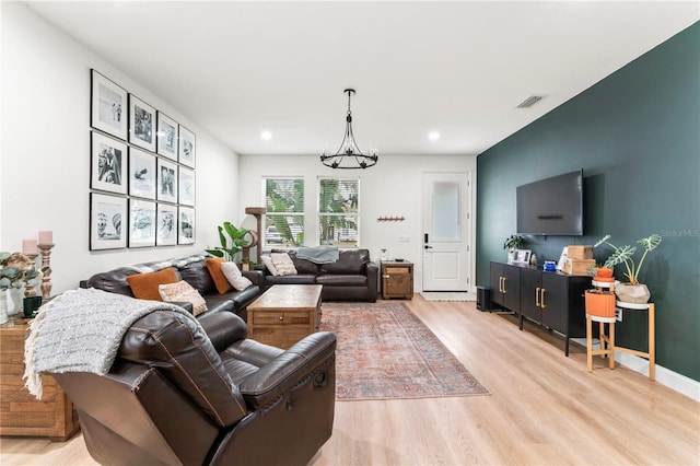 living room with a notable chandelier and light hardwood / wood-style floors