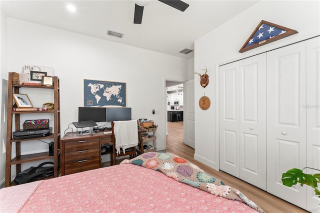 bedroom with light hardwood / wood-style floors, a closet, and ceiling fan