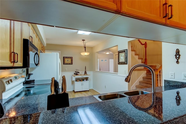 kitchen featuring pendant lighting, white electric range, sink, and light hardwood / wood-style flooring