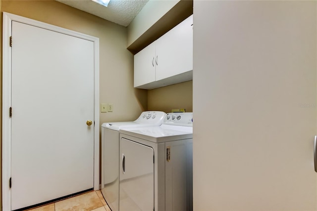 laundry room featuring cabinets, light tile patterned floors, and independent washer and dryer