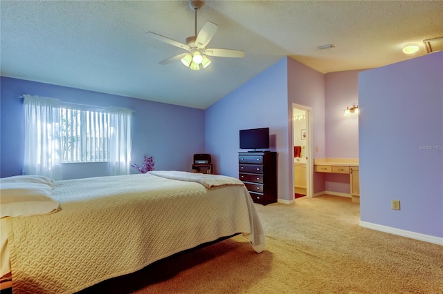 carpeted bedroom with ceiling fan, ensuite bath, vaulted ceiling, and a textured ceiling