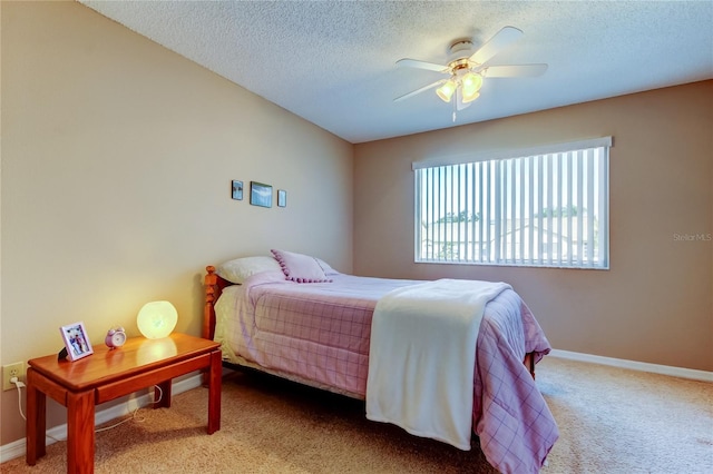 carpeted bedroom featuring ceiling fan and a textured ceiling