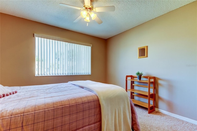 bedroom featuring light carpet, ceiling fan, and a textured ceiling