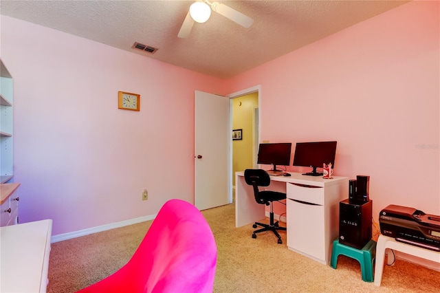 office space with light carpet, ceiling fan, and a textured ceiling