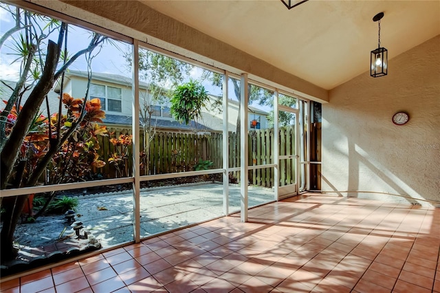 unfurnished sunroom featuring a healthy amount of sunlight and lofted ceiling