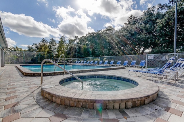 view of pool with a hot tub