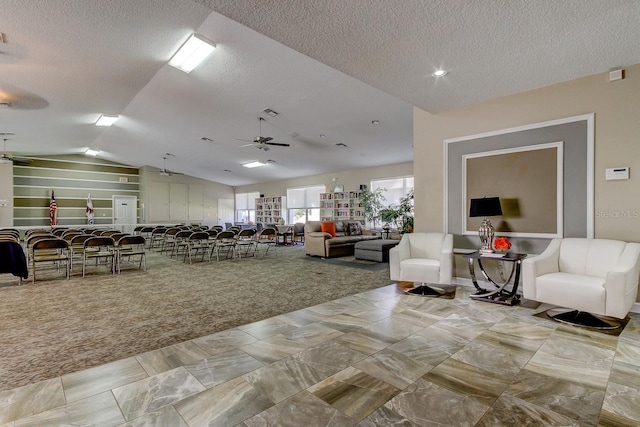 carpeted living area featuring a textured ceiling, a ceiling fan, and vaulted ceiling