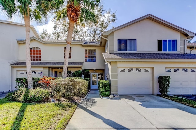 view of front of house with an attached garage, driveway, and stucco siding