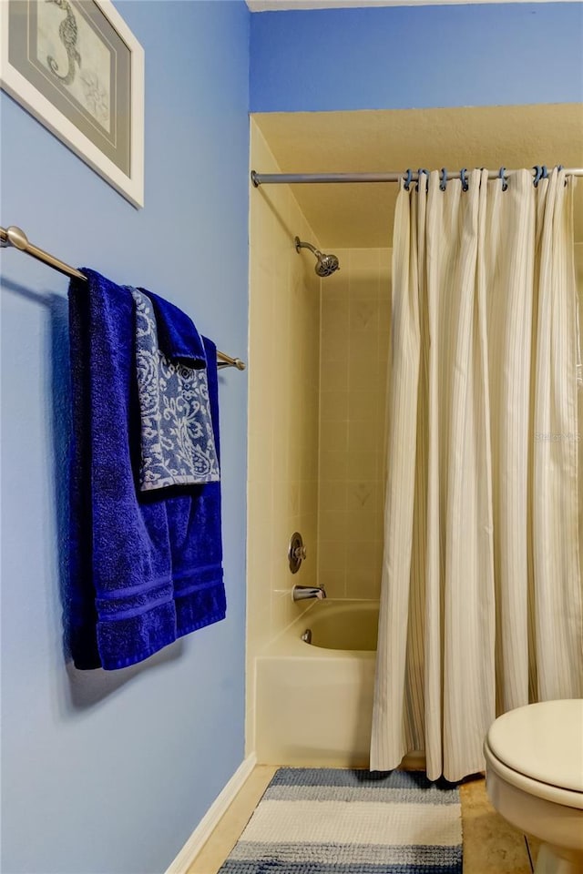 full bathroom with tile patterned flooring, toilet, baseboards, and shower / bath combo with shower curtain