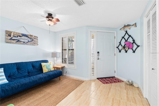 entrance foyer with ceiling fan and a textured ceiling