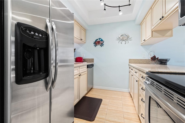 kitchen featuring stainless steel appliances, rail lighting, cream cabinetry, and a tray ceiling