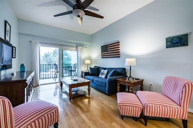 living room featuring ceiling fan and light hardwood / wood-style floors