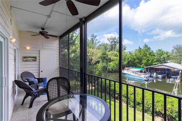 sunroom featuring a water view and ceiling fan