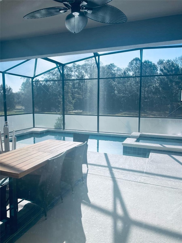 view of patio / terrace featuring ceiling fan and glass enclosure