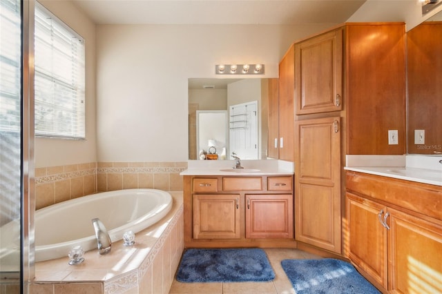 bathroom with a relaxing tiled tub, tile patterned floors, and vanity