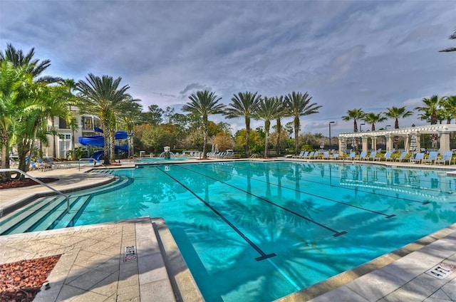 view of pool with a water slide and a patio area