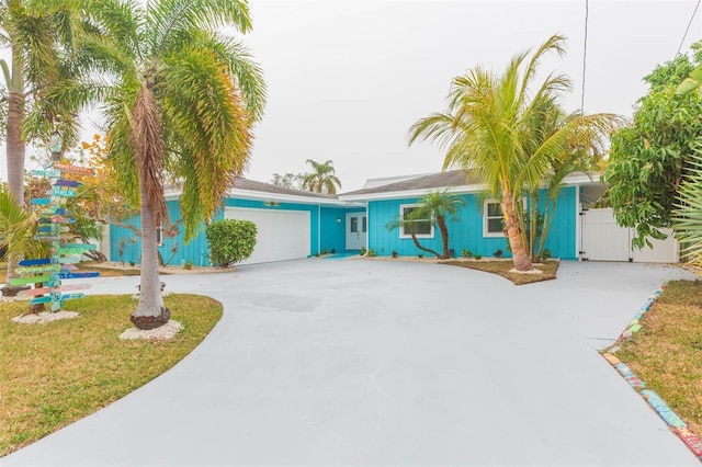 single story home with a garage, driveway, and a gate