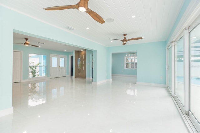 empty room with wood ceiling, ceiling fan, and a wealth of natural light