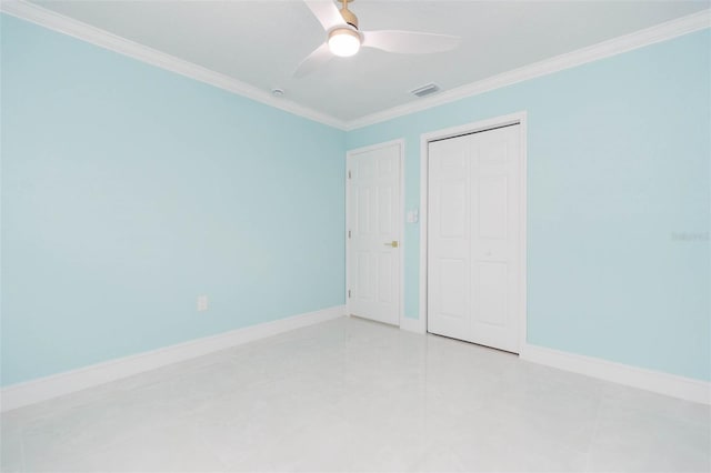 unfurnished bedroom featuring crown molding, light tile patterned floors, ceiling fan, and a closet