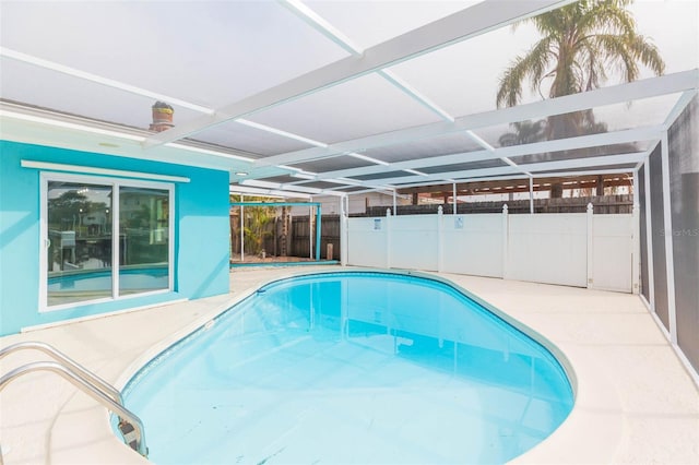 view of swimming pool with a patio and glass enclosure