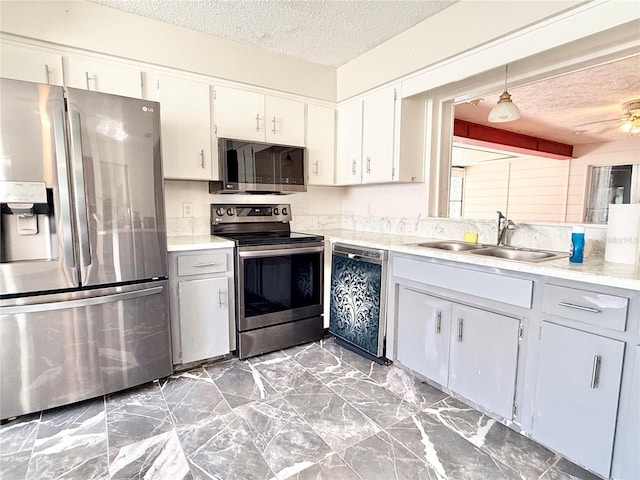 kitchen with stainless steel appliances, sink, a textured ceiling, and white cabinets