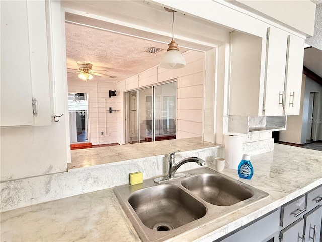 kitchen featuring sink, ceiling fan, gray cabinetry, hanging light fixtures, and white cabinets