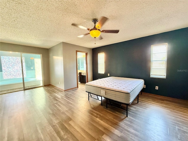 bedroom with ceiling fan, a textured ceiling, and light wood-type flooring