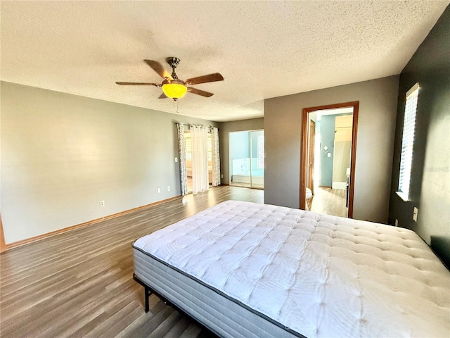 bedroom with hardwood / wood-style floors, ensuite bathroom, a textured ceiling, and ceiling fan