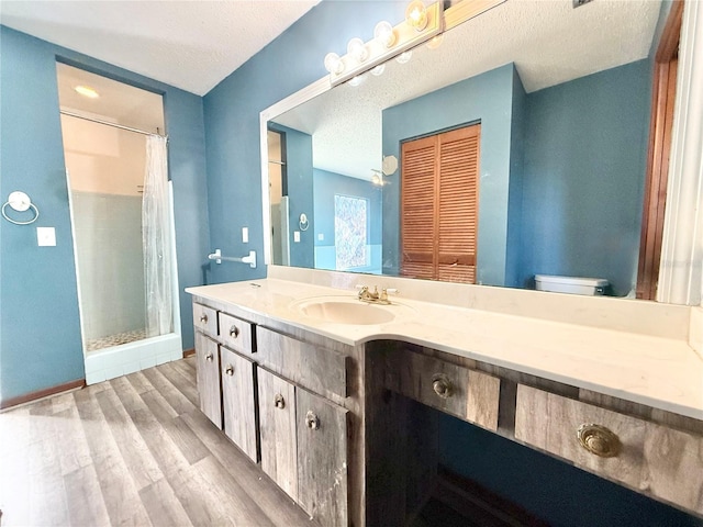 bathroom with wood-type flooring, vanity, toilet, a textured ceiling, and a shower with curtain