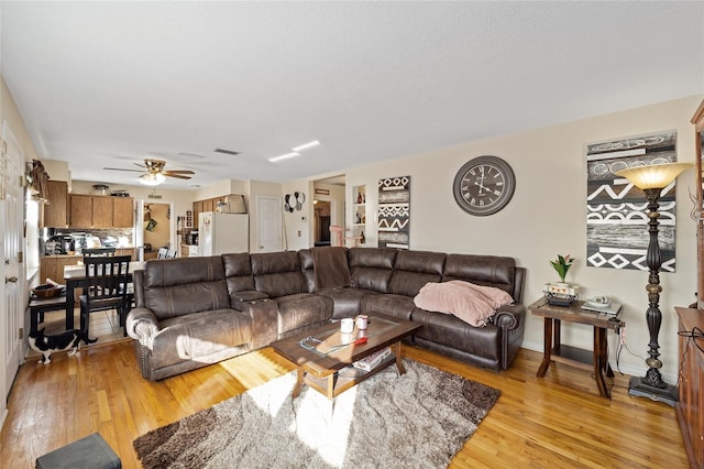 living room featuring ceiling fan and light wood-type flooring