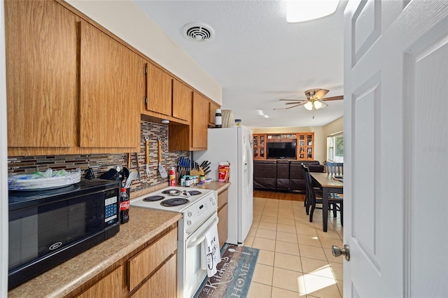 kitchen featuring a textured ceiling, light tile patterned floors, ceiling fan, white appliances, and backsplash