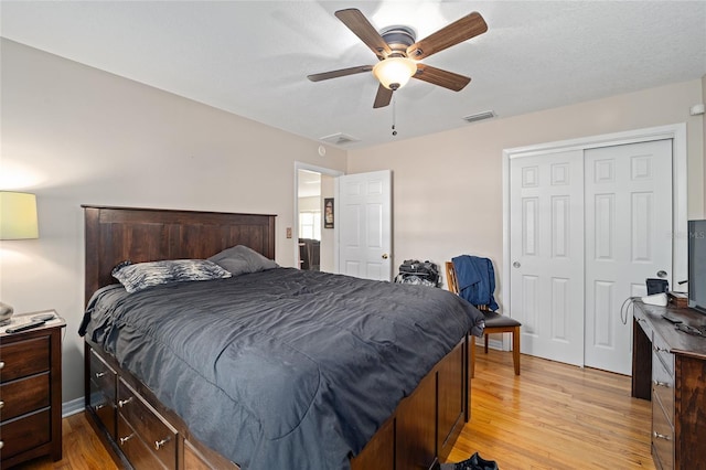 bedroom featuring ceiling fan, light hardwood / wood-style floors, and a closet