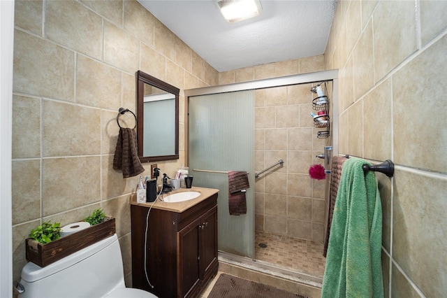 bathroom with vanity, toilet, tile walls, and walk in shower