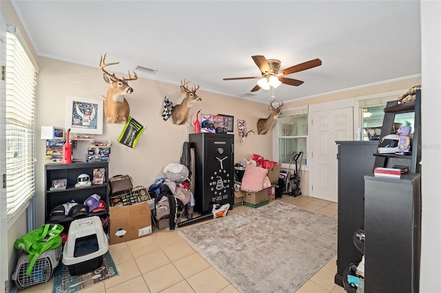 interior space featuring ornamental molding, light tile patterned floors, and ceiling fan