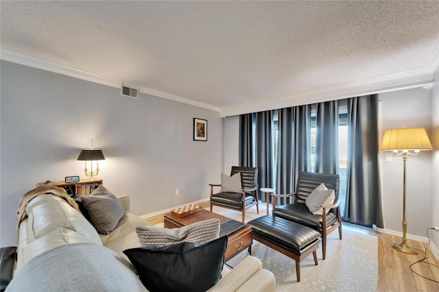 living room featuring ornamental molding, light hardwood / wood-style floors, and a textured ceiling