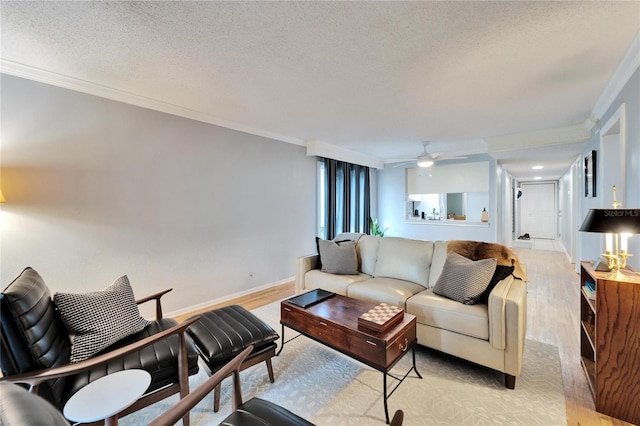 living room featuring crown molding, ceiling fan, light hardwood / wood-style floors, and a textured ceiling