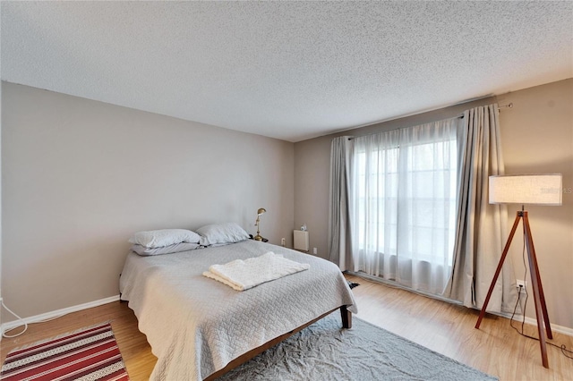 bedroom featuring hardwood / wood-style flooring and a textured ceiling