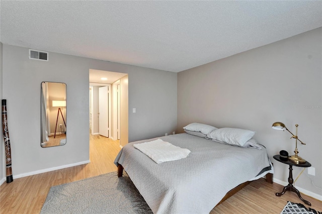 bedroom featuring a textured ceiling and light wood-type flooring