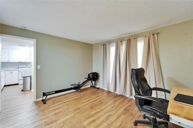 office area with a textured ceiling and light wood-type flooring