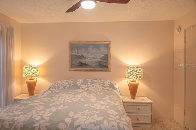 carpeted bedroom with ceiling fan and a textured ceiling