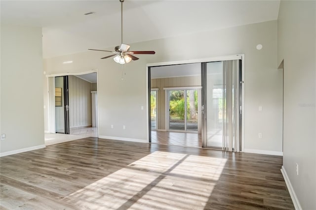 empty room featuring a high ceiling, hardwood / wood-style floors, and ceiling fan