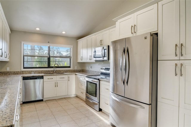 kitchen featuring sink, light tile patterned floors, appliances with stainless steel finishes, light stone countertops, and white cabinets