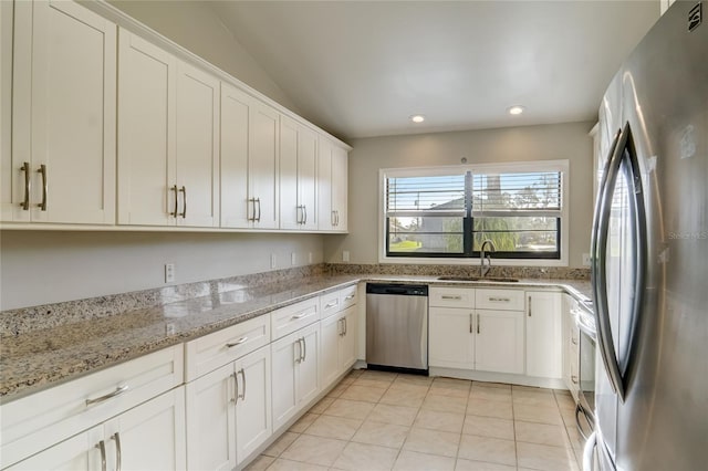 kitchen featuring white cabinetry, appliances with stainless steel finishes, sink, and light stone counters